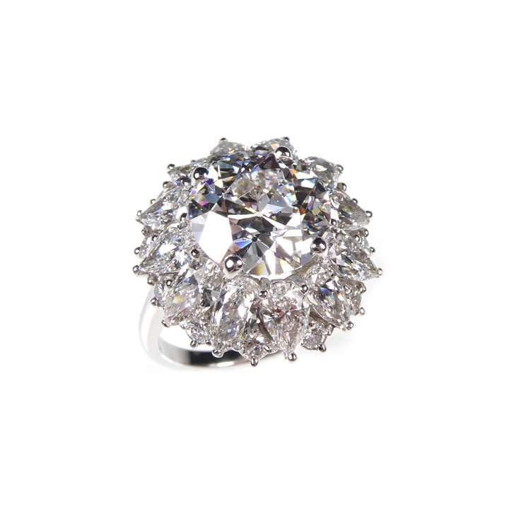 Round brilliant cut diamond and pear diamond cluster ring